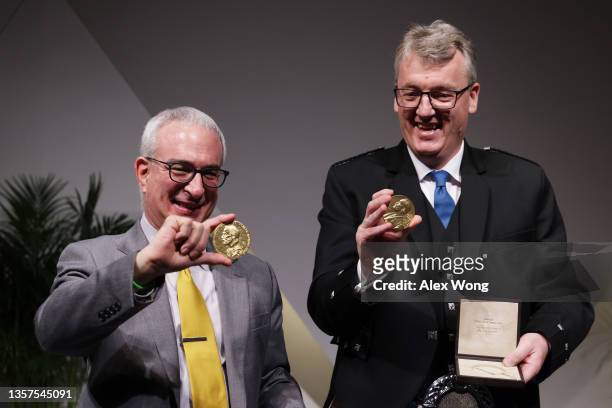Economic sciences laureate Joshua Angrist and chemistry laureate David MacMillan pose for photos with their Nobel Prize medals during a ceremonial...