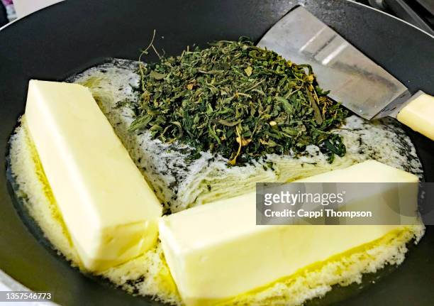 butter and cannabis ready to simmer in frying pan - geköchelt stock-fotos und bilder