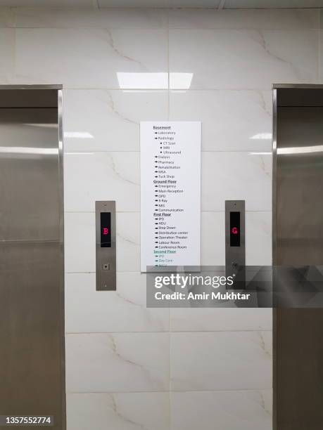 hospital stainless steel elevator control panels and display on tiled wall. - door close button imagens e fotografias de stock