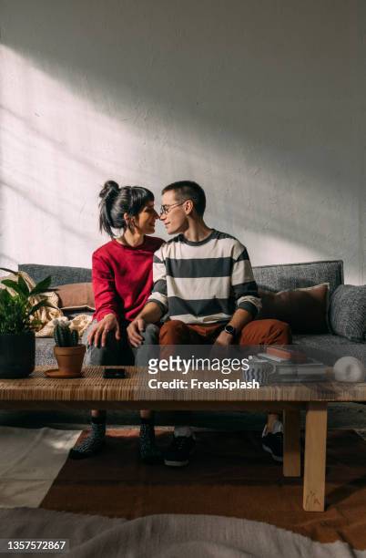 una giovane coppia felice di trascorrere un po' di tempo insieme a casa - coppia eterosessuale foto e immagini stock