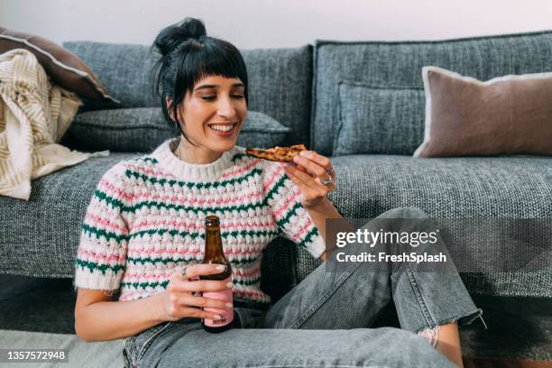 a hungry woman being happy to eat pizza and drink some beer - single adults eating dinner at home stock pictures, royalty-free photos & images