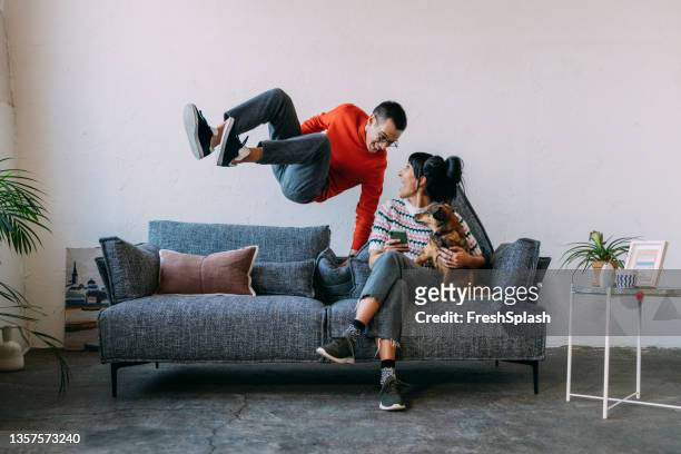 ein mann und seine frau - freuen sich, wieder zusammen zu sein - sofa stock-fotos und bilder