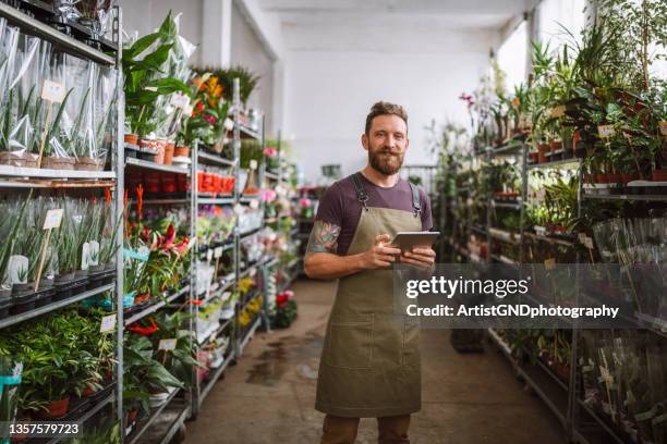 florist using digital tablet in flower shop - computer store stockfoto's en -beelden