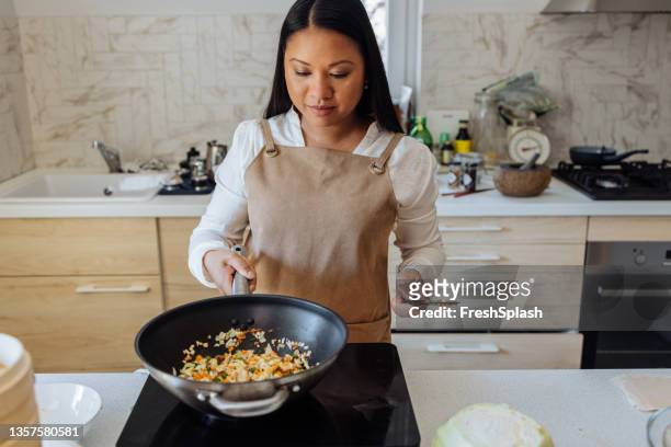beautiful woman preparing healthy meal in her kitchen - hot filipina women stockfoto's en -beelden