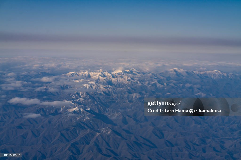 Snowcapped Hidaka Mountains in Hokkaido of Japan aerial view from airplane