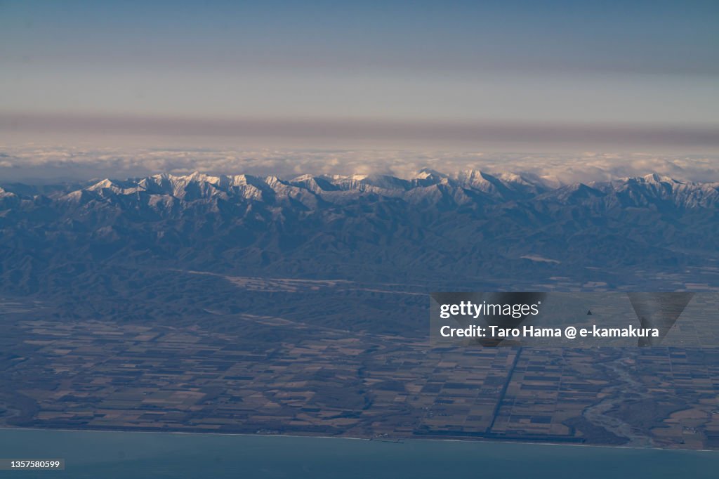 Snowcapped Hidaka Mountains in Hokkaido of Japan aerial view from airplane
