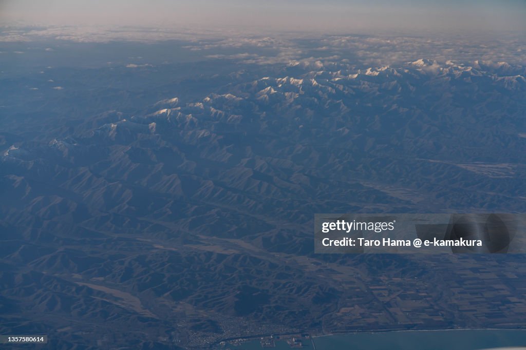 Snowcapped Hidaka Mountains in Hokkaido of Japan aerial view from airplane