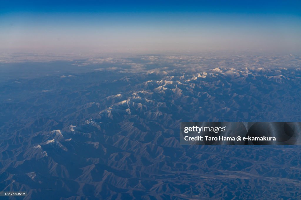 Snowcapped Hidaka Mountains in Hokkaido of Japan aerial view from airplane