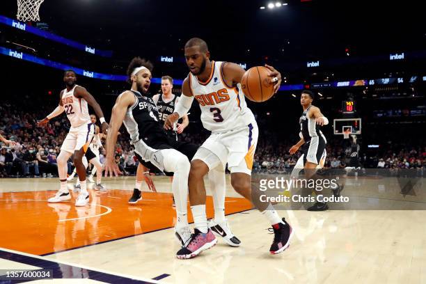 Chris Paul of the Phoenix Suns fouls Derrick White of the San Antonio Spurs during the third quarter at Footprint Center on December 06, 2021 in...