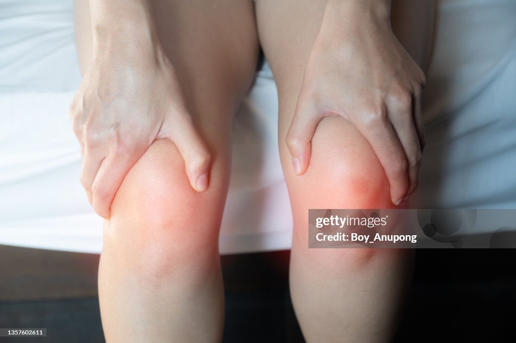 Cropped shot of woman holding her knee caused of knee pain.