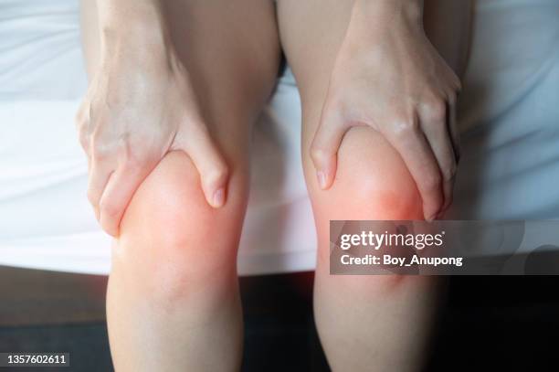 cropped shot of woman holding her knee caused of knee pain. - weakness stock pictures, royalty-free photos & images