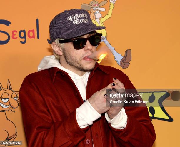 Pete Davidson smokes as he arrives at TUBI's "The Freak Brothers" experience at Fred Segal on December 06, 2021 in Los Angeles, California.