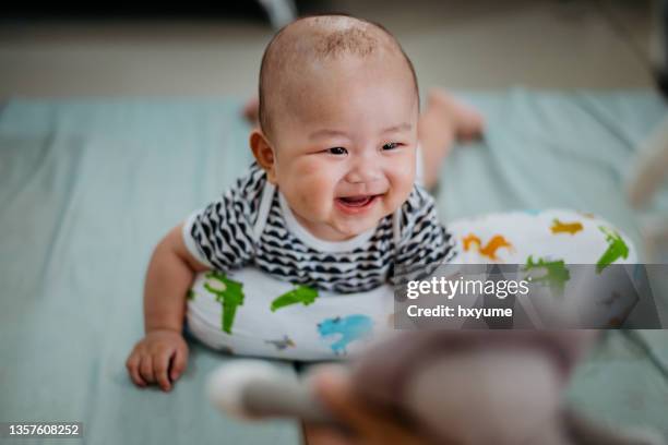 asian baby having tummy time on mattress - baby girl laying on tummy stock pictures, royalty-free photos & images