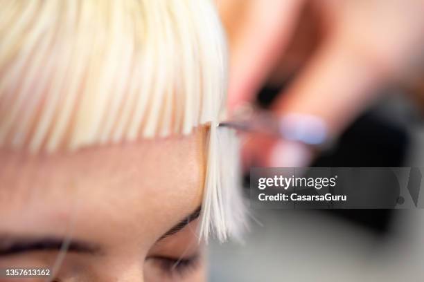 close-up of young woman getting her bangs cut - fringe stock pictures, royalty-free photos & images
