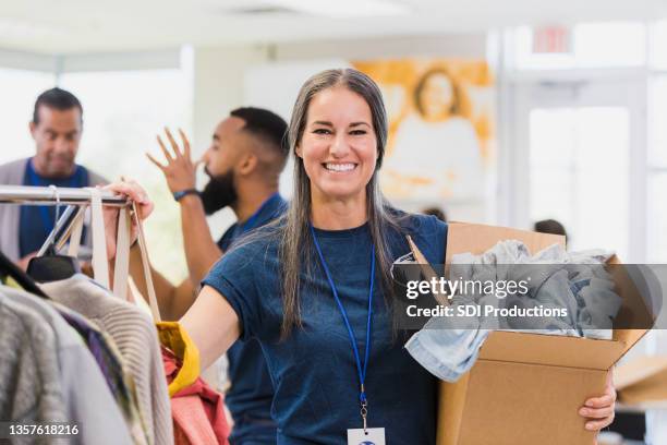 mittlere erwachsene weibliche kleidung drive organizer posen für foto - frau mittleren alters stock-fotos und bilder