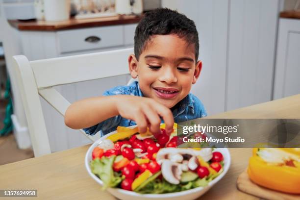 shot of a little boy eating vegetables - kid eating stock pictures, royalty-free photos & images