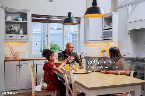 shot of a young family enjoying a meal together - jantar imagens e fotografias de stock