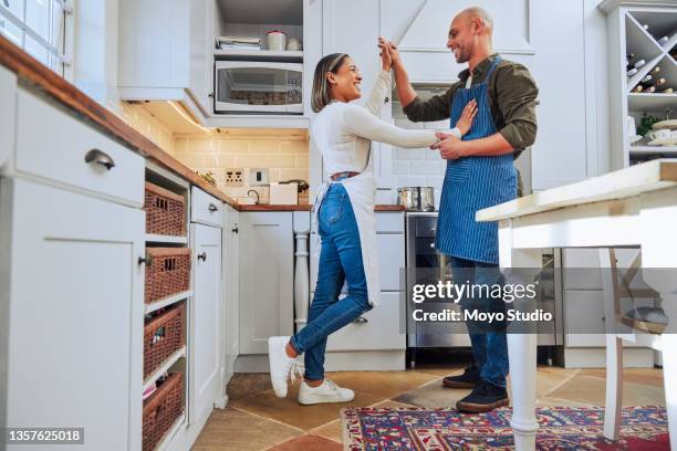 foto de una joven pareja bailando en su cocina mientras cocinan juntos - couples making passionate love fotografías e imágenes de stock