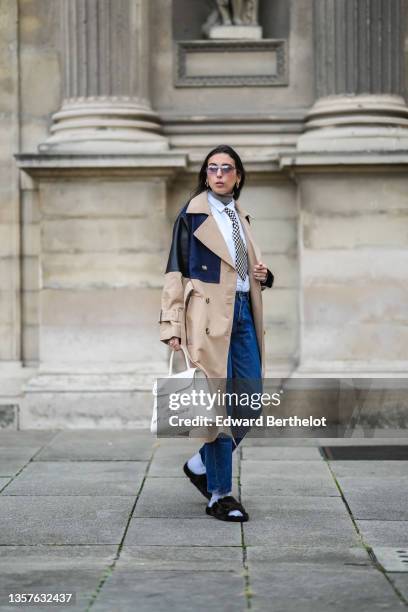 Gabriella Berdugo wears sunglasses from Gucci, gold earrings, a brown ribbed wool turtleneck pullover, a white shirt from Wrangler, a black and white...