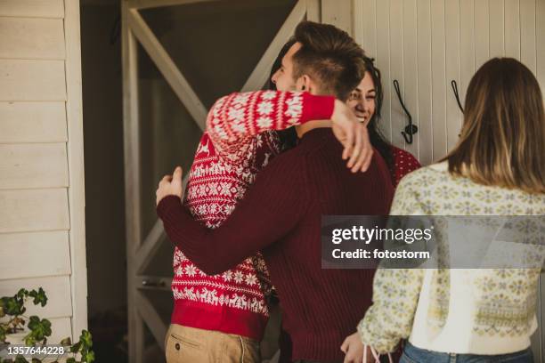 copy space shot of two male friends embracing each other at the front door - fall party arrivals stockfoto's en -beelden