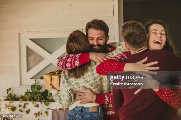 amigos alegres cumprimentando e abraçando uns aos outros ao chegar - alo house winter - fotografias e filmes do acervo