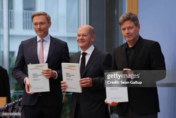 Olaf Scholz of the German Social Democrats , Robert Habeck of the Greens Party and Christian Lindner of the German Free Democrats hold up the...