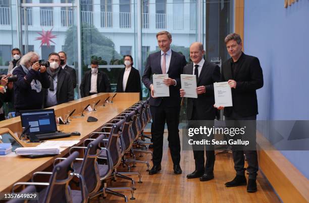 Olaf Scholz of the German Social Democrats , Robert Habeck of the Greens Party and Christian Lindner of the German Free Democrats hold up the...