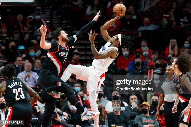Terance Mann of the Los Angeles Clippers shoots the ball over Jusuf Nurkic of the Portland Trail Blazers during the first half at Moda Center on...