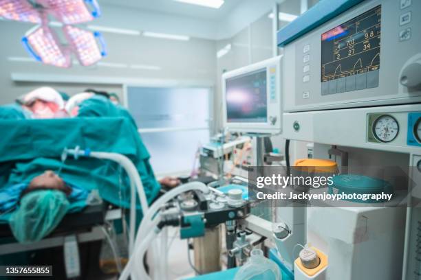 medical ventilator being monitored and unrecognized medical staff in background. - respiratory machine stock-fotos und bilder