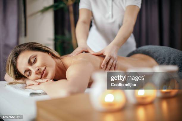 attractive young woman receiving relax back massage - healing hands stockfoto's en -beelden