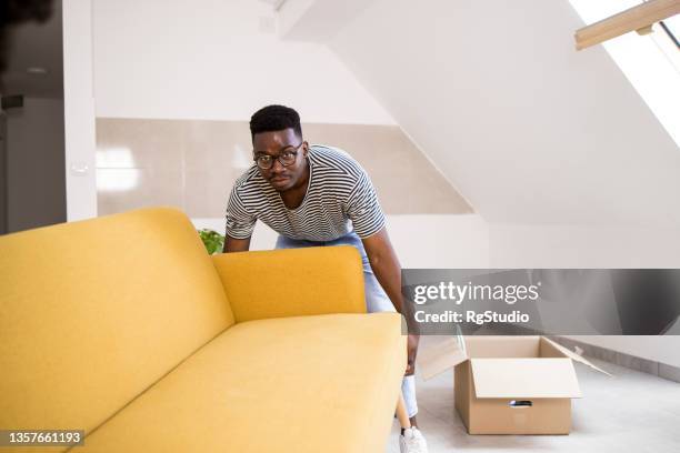 african american man moving into his new apartment - man with moving boxes authentic stockfoto's en -beelden