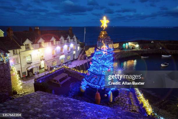 christmas tree overlooking clovelly illuminated at night - exeter devon stock-fotos und bilder