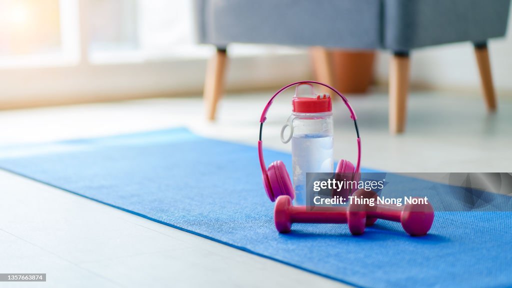 Sports equipment with water and earphones on inside the house background