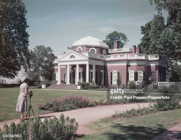 Woman takes a photograph of Thomas Jefferson's main house at Monticello, his primary plantation located just outside Charlottesville in Virginia,...
