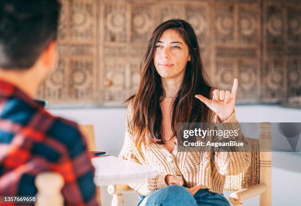 dos amigos están charlando en el café con lenguaje de señas - sign language fotografías e imágenes de stock