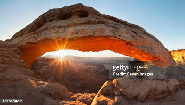 sunrise on cayonland's mesa arch in utah. - arco mesa foto e immagini stock