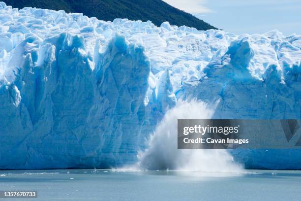 ice calving off of the perito moreno glacier. - international landmark stock pictures, royalty-free photos & images