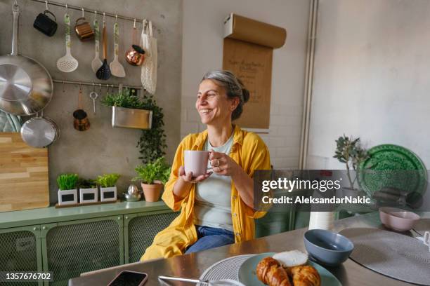 woman having a first morning coffee in the kitchen - coffee and milk stock pictures, royalty-free photos & images