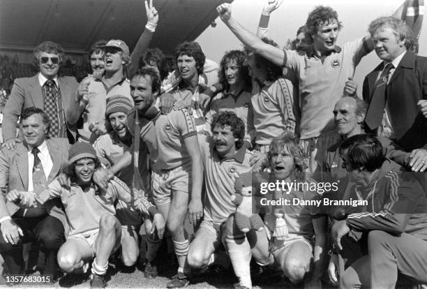 Brighton players including captain Brian Horton Peter Ward and manager Alan Mullery celebrate promotion to Division One on the pitch after their 3-1...