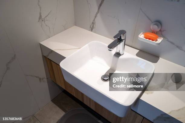 overlooking porcelain bathroom sink - bathroom sink stock-fotos und bilder