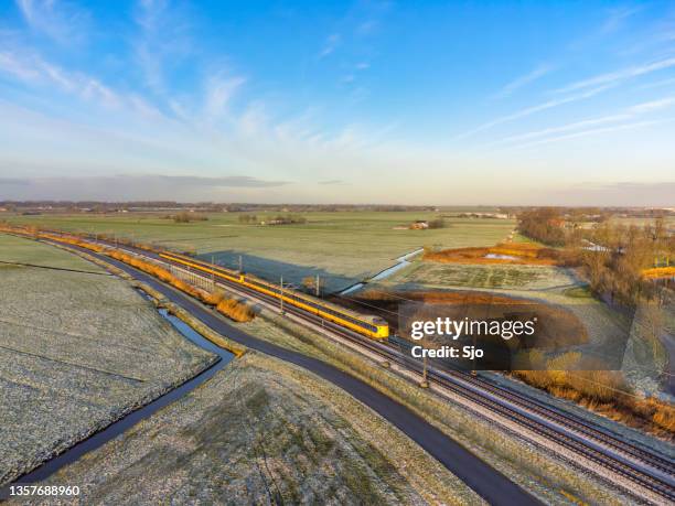 train of the dutch railways ns driving through the countryside during winter - kampen overijssel stock pictures, royalty-free photos & images