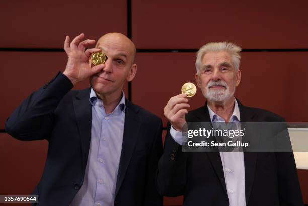 Benjamin List , Laureate of the 2021 Nobel Prize in Chemistry, and Klaus Hasselmann, Laureate of the 2021 Nobel Prize in Physics, hold up chocolate...