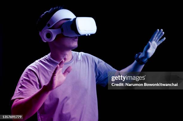 the man playing metaverse via vr goggles and futuristic hologram - fake man stockfoto's en -beelden