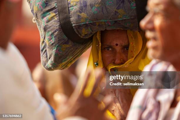 photo of senior indian woman carrying bag on her had, rishikesh, india - uttarakhand stock pictures, royalty-free photos & images