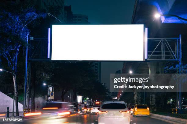 blank billboard on city street at night. outdoor advertising - billboard highway stock-fotos und bilder