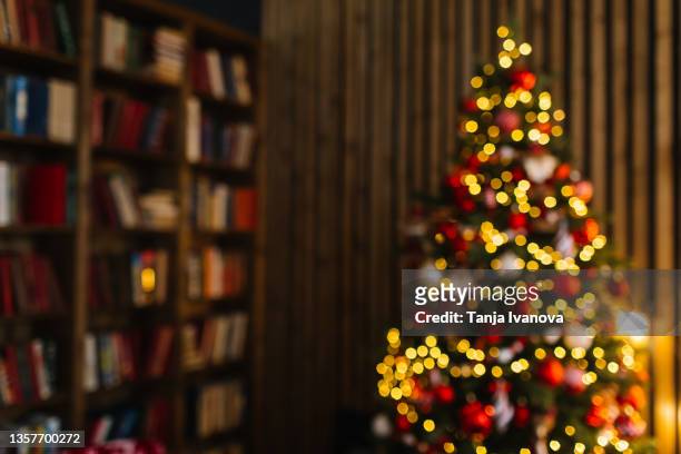blurry christmas background with christmas tree with glowing garlands of lights. concept of celebrating new year - christmas tree photos et images de collection