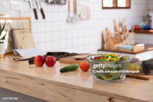 wide angle shot of salad bowl and various vegetables setting on kitchen counter at  white kitchen style. - plain salad stock pictures, royalty-free photos & images