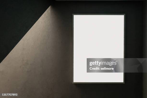 empty picture frame on concrete wall with light effect - poster mockup stock-fotos und bilder