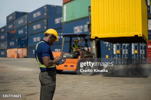 Foreman using digital tablet for check forklift driver loading containers box from Cargo freight ship for import export. Foreman using digital tablet for check forklift driver loading containers box from Cargo freight ship for import export.
