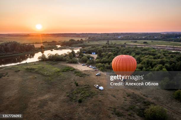 summer landscape at the mouth of the klyazma river in the vladimir region. an orange balloon prepares for takeoff. sunset in the russian field - silver balloon imagens e fotografias de stock